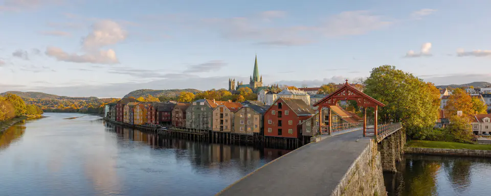 Illustrated view of Trondheim's Nidelva with colorful wharf houses, the Old Town Bridge, and Nidaros Cathedral